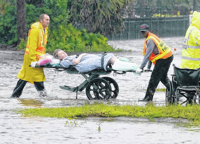 Authorities transport a person out of the Avante nursing home in the aftermath of Hurricane Ian on Thursday in Orlando, Florida. Hurricane Ian carved a path of destruction across Florida, trapping people in flooded homes, cutting off the only bridge to a barrier island, destroying a historic waterfront pier and knocking out power to 2.5 million people as it dumped rain over a huge area on Thursday.
                                 John Raoux | AP