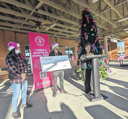 <p>Terri Dennison addresses the crowd as Irra and DeTre gleam behind her.</p>