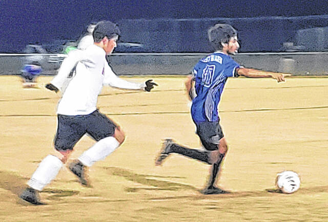 131909795_web1_East_Bladen_Roxboro_soccer
East Bladens Ishaq Algozy (blue) dribbles the ball against Roxboro Community.
Sonny Jones / Bladen Journal