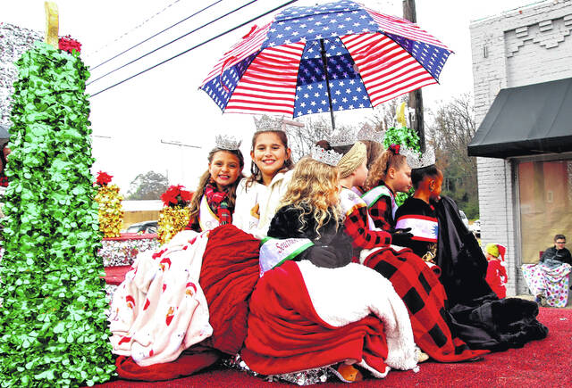 <p>The kingdom of queens were huddled under a patriotic covering that barely kept them all from the cool stinging rain that began to fall somewhere around 11 a.m.</p>