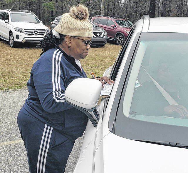 Theresa Burns collects information from people who have come to pick up a box of food at Joy Fellowship Outreach Ministry.
                                 Sonny Jones / Bladen Journal
