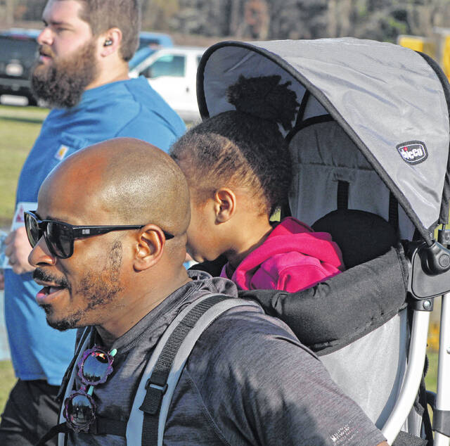 Ray Davis carries his toddler on his back during the Wine Run 5k.
                                 Sonny Jones / Bladen Journal