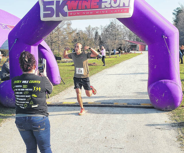 Kenry Locklear crosses the finish line at the Wine Run 5k at Lu Mil Vineyard. He won the mens 40-49 age group.
                                 Sonny Jones / Bladen Journal