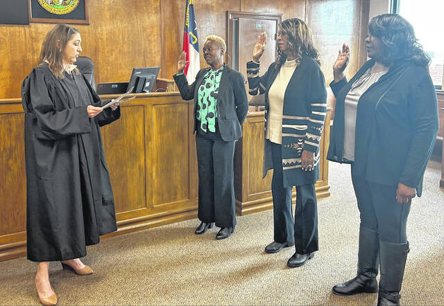 Judge Sarah B. McPherson swears in Guardian ad Litem volunteers, from left, Angela Smith, Dianna McKenzie and Stephanie Newkirk inside the Bladen County Courthouse on Wednesday, March 18.
                                 Contributed photo