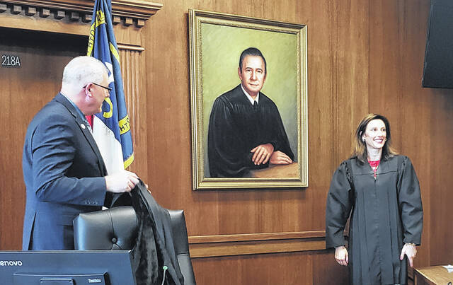 Chief District Court Judge Scott Ussery and Superior Court Judge Ashley Gore unveil the portrait of retired Judge Giles Clark that will hang inside the Superior Courtroom of the Bladen County Courthouse.
                                 Sonny Jones / Bladen Journal