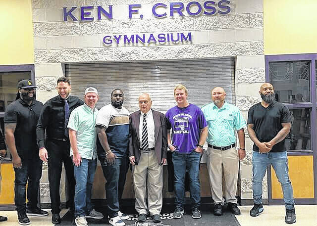 Ken Cross (middle) poses with some of his former West Bladen High School basketball players during the ceremony in 2023 naming the schools gymnasium in his honor.
                                 Staff file photo