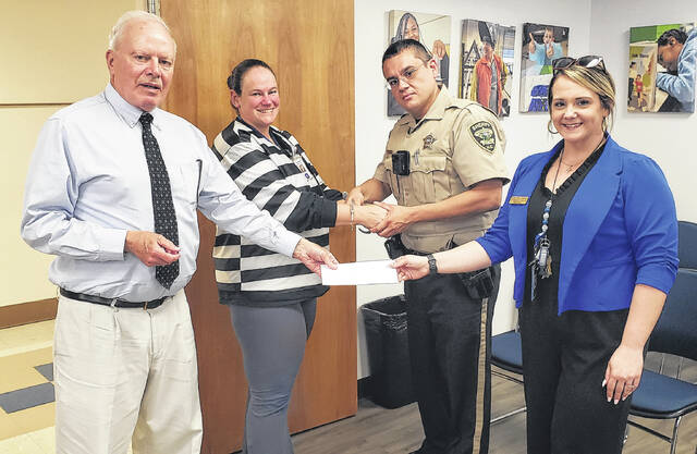Marie Boomhower (second from left) of Clarkton School of Discovery has handcuffs removed by Sheriffs Office School Resource Officer Luis Munoz as Bladen County Educational Foundation treasurer David Wall (left) and CSD principal Amanda Murillo look on during the Jail-A-Thon on Thursday, April 23.
                                 Sonny Jones / Bladen Journal