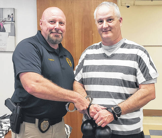 Elizabethtown Primarys Chris Cherry (right) is arrested by White Lake Police Chief Bruce Smith during the Jail-A-Thon on Thursday, April 23.
                                 Sonny Jones / Bladen Journal