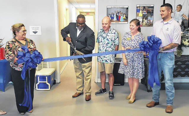 Carl Carter of My Treasured Memories cuts the ribbon Friday, April 24 to officially open his photography and videography business in Elizabethtown.
                                 Sonny Jones / Bladen Journal
