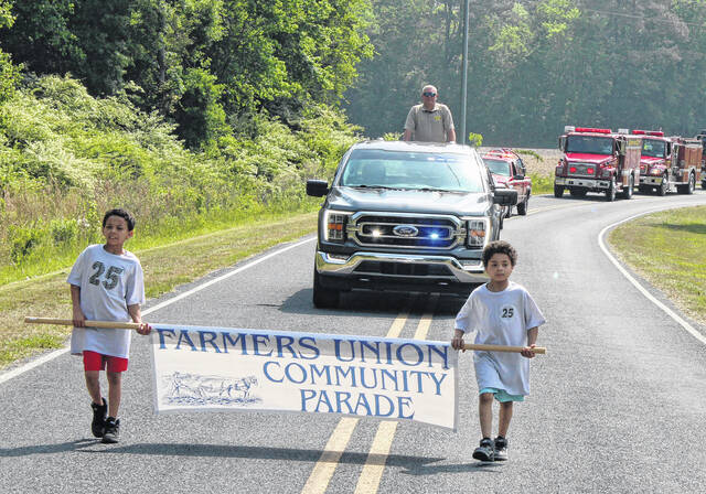 Youngsters carry a banner signifying the start of the Farmers Union SpringFest parade.
                                 Sonny Jones / Bladen Journal