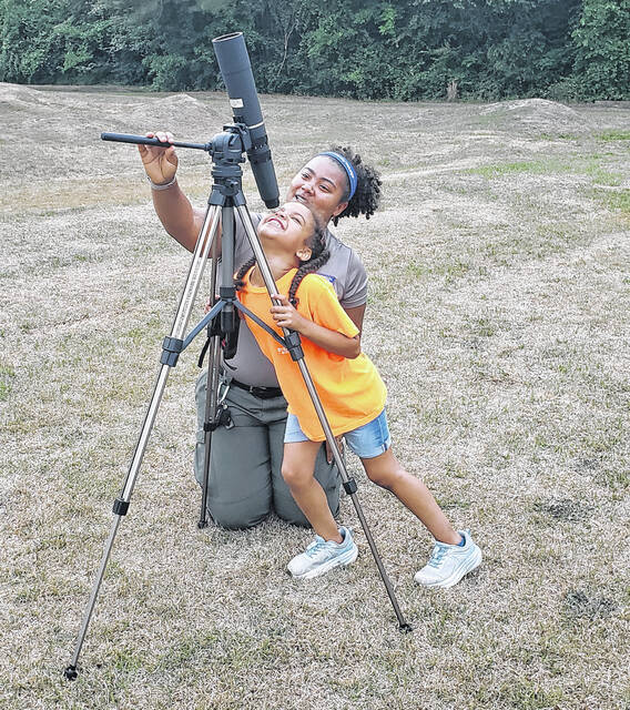Monique McKoy from Jones Lake State Park helps a youngster use a telescope to look straight up at the moon.
                                 Sonny Jones / Bladen Journal