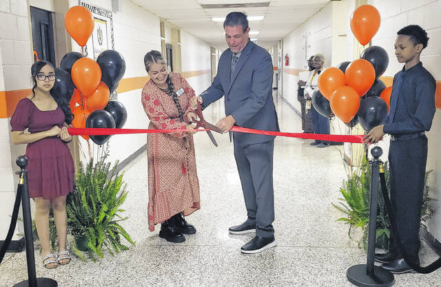 Bladen County Community Schools coordinator Anastasiia Chapman (left) and Elizabethtown Middle School Prinicipal Bobby Godwin cut the ribbon Thursday, April 30 to official open the Cougar Family Hub Resource Center.
                                 Sonny Jones / Bladen Journal