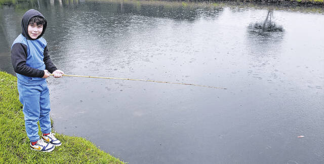 8-year-old Christian tries to catch a fish from the pond at Lu Mil Vineyard.
                                 Sonny Jones / Bladen Journal