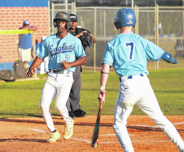 East Bladens Davion Lewis (2) cross home plate with a run after teammate Zach Sholar (7) scored.
Kenneth Armstrong / kenarmphoto.com