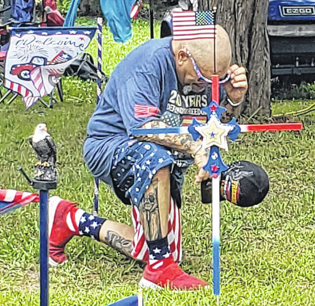 A man prays during the playing of Taps in remembrance of United States service members who have died.
Sonny Jones / Bladen Journal