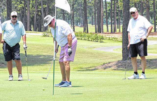 Golfers watch a putt roll toward the hole on No. 9 during the Whack Smack It tournament Friday, June 12 at Vineyard Golf at White Lake.
                                 Sonny Jones / Bladen Journal